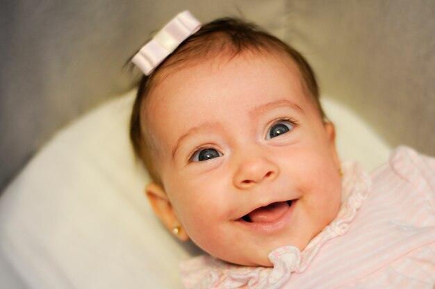 Baby girl two months old smiling indoors