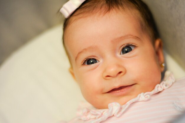 屋内で笑顔の2ヶ月の赤ちゃんの女の子
