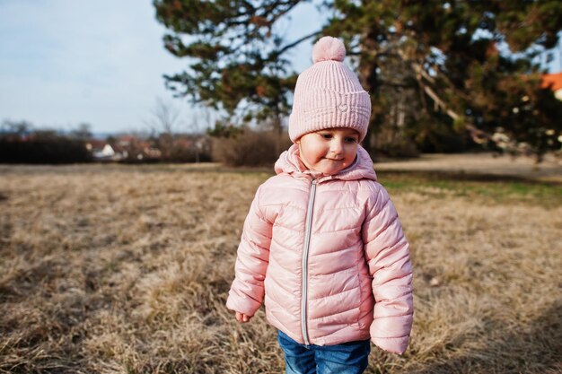 女の赤ちゃんは、チェコ共和国ヴァルチツェ公園で歩くピンクのジャケットを着ています
