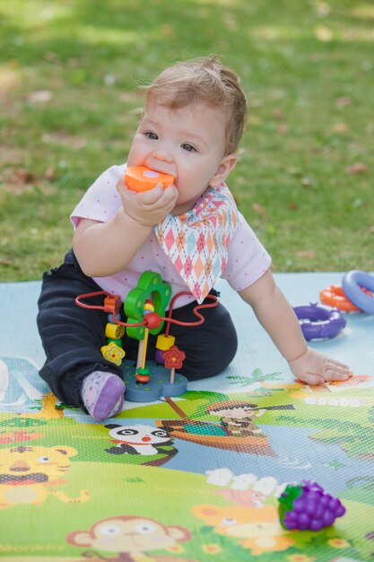 Baby, less than a year old   playing with  toy