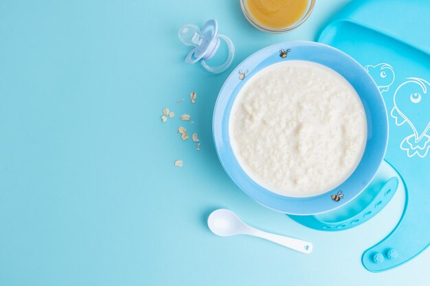 Baby plate with porridge on blue