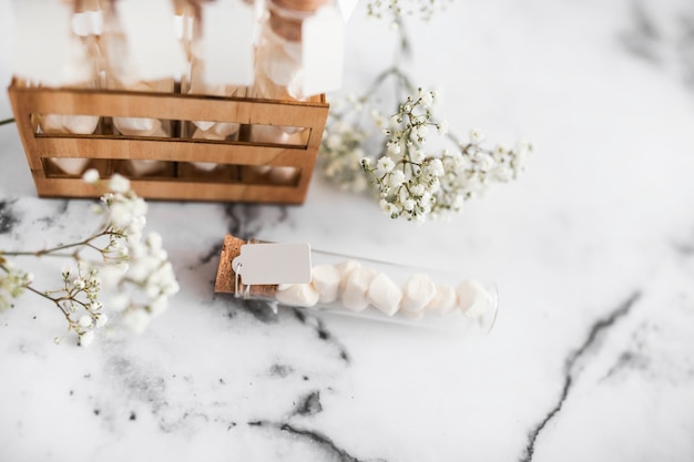 Baby's-breath flowers and marshmallow test tubes on textured background