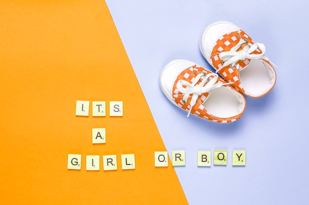 「それは女の子」または「それは男の子」のレタリングが付いたベビーシューズまたは幼児用シューズの上面図。