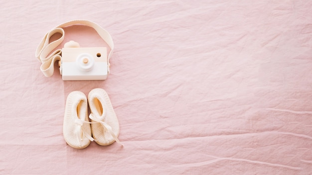 Foto gratuita baby-scarpe e macchina fotografica giocattolo