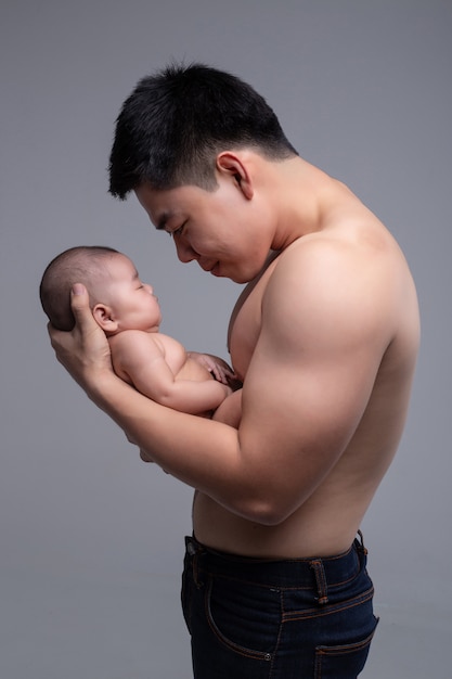 아기는 강한 아버지의 손에 잔다.
