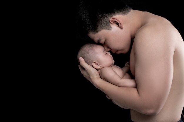 아기는 강한 아버지의 손에 잔다.