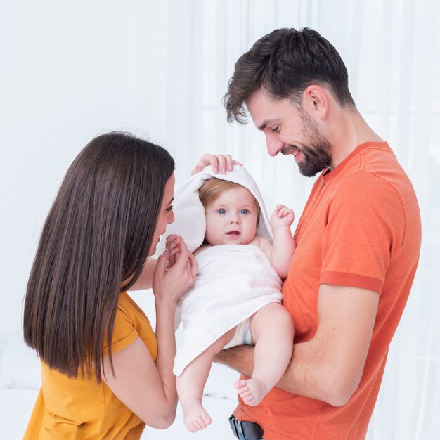 Baby in towel held by parents