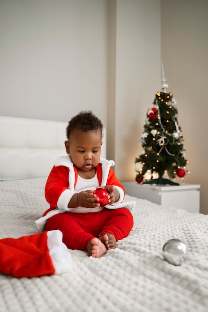 Foto gratuita bambino che indossa il vestito da babbo natale a tutto campo