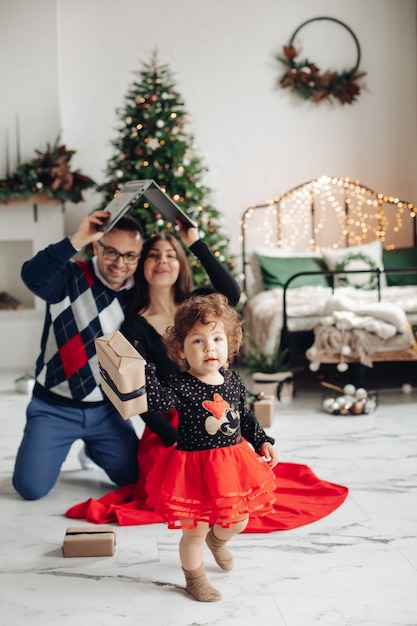 Free photo baby with present, parents with laptop.