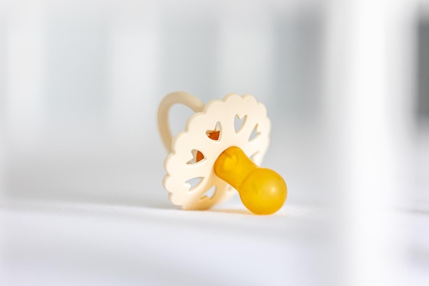 Free photo babys pacifier on a blurred white background