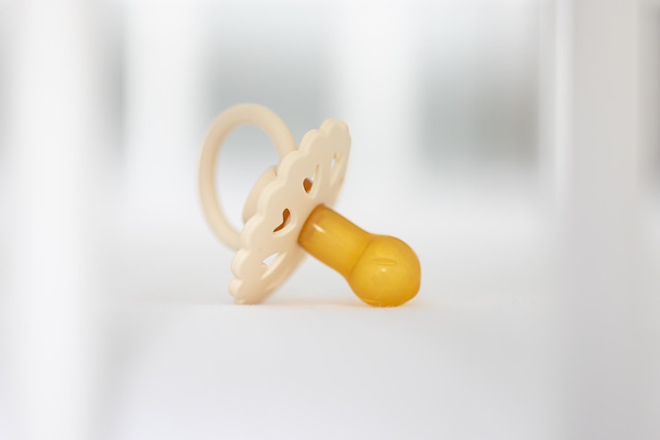 Free Photo babys pacifier on a blurred white background