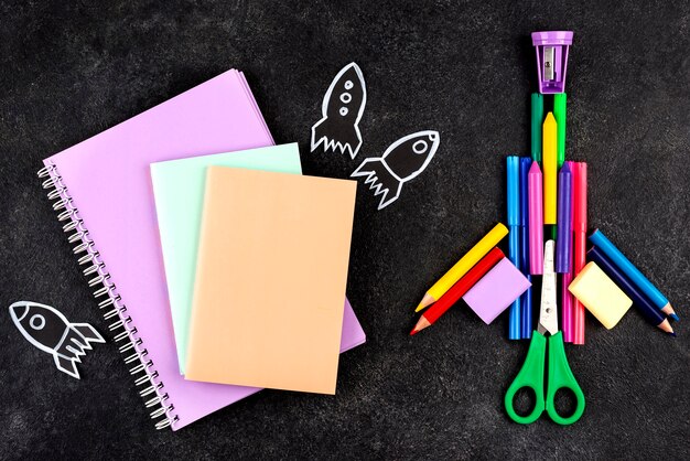 Back to school background with rocketship and notebooks