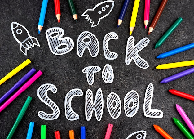 Free photo back to school background with school supplies on chalkboard