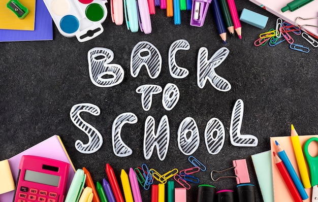 Free photo back to school background with school supplies on chalkboard