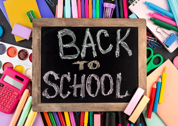 Free photo back to school background with school supplies and chalkboard