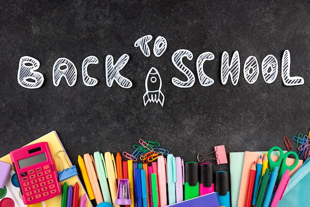 Back to school background with school supplies on chalkboard