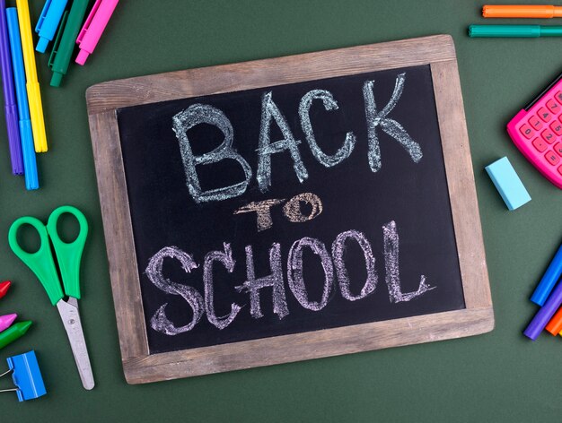 Back to school background with school supplies and chalkboard