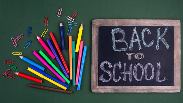 Free photo back to school background with school supplies and chalkboard