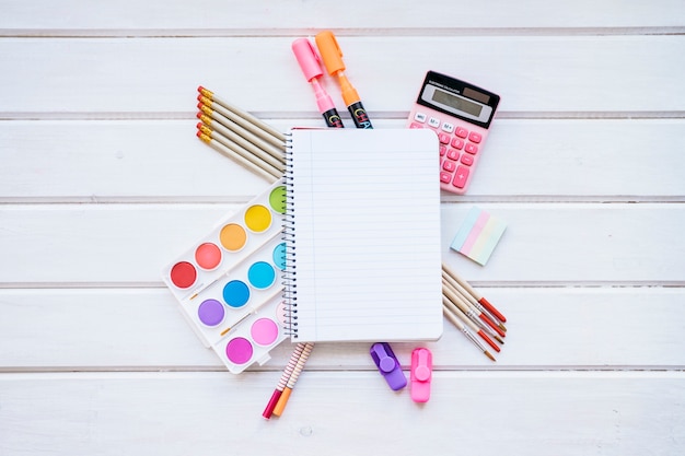 Back to school composition with notepad on wooden surface