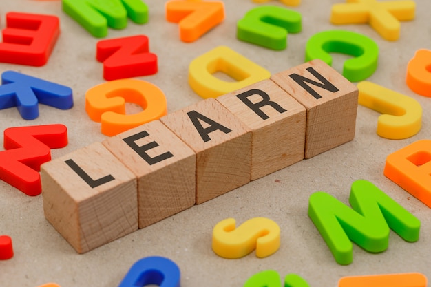 Free photo back to school concept with alphabet letters, wooden cubes on paper high angle view.