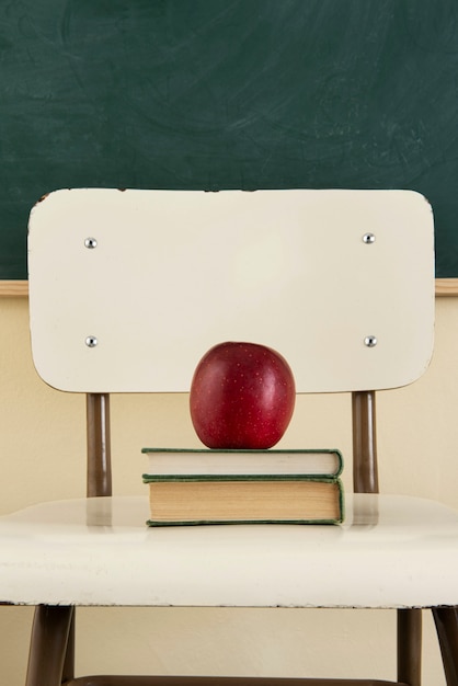 Вернуться к школьной концепции с яблоком на стуле
