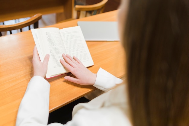 Di nuovo al concetto del banco con la fine in su della donna che studia nella libreria