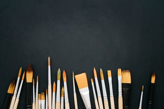 Back to school concept with paint brushes on dark surface