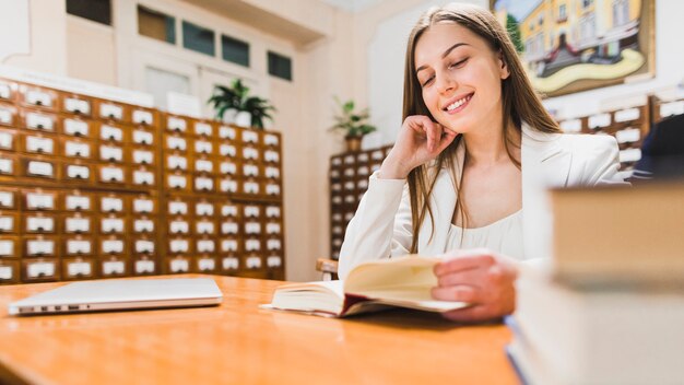 Di nuovo al concetto della scuola con la donna che studia nella biblioteca