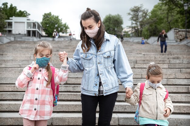 学校に戻る。コロナウイルスのパンデミックの子供たちはマスクをして学校に行きます。母との友好関係。