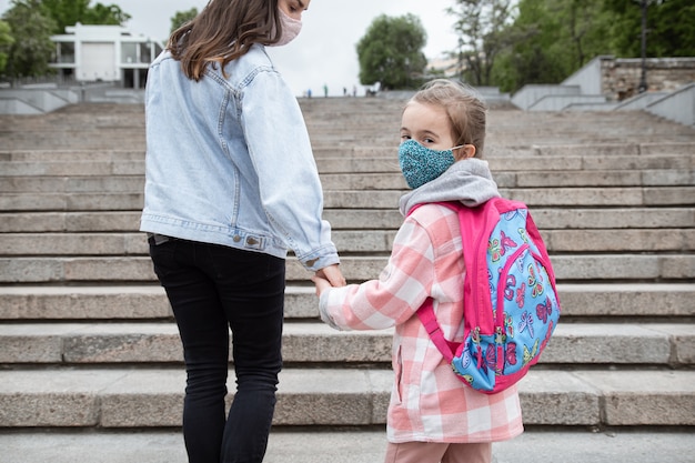 학교로 돌아가다. 코로나 바이러스 대유행 아동은 마스크를 쓰고 학교에갑니다. 어머니와의 우호적 인 관계.
