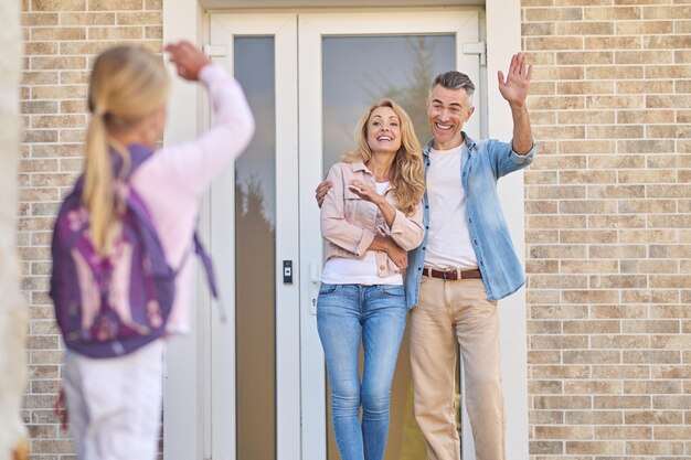 Back to school. Parents sending a girl to sschool in the morning