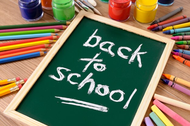 Free photo back to school written on a blackboard with crayons