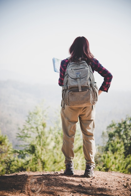 Free photo back side of traveler girl searching right direction on map, while traveling to hiking in the mountain. travel concept.