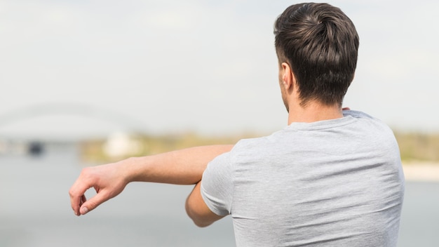 Free photo back view adult male stretching