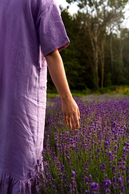 Adulto di vista posteriore che cammina nel campo di lavanda