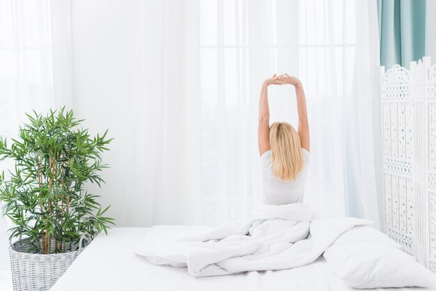 Back view adult woman waking up at home