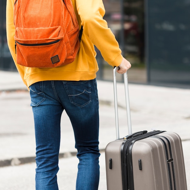 Back view alone traveler with luggage