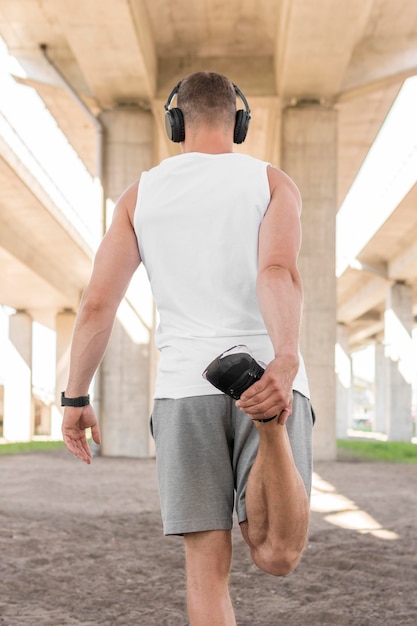 Free photo back view athletic man stretching