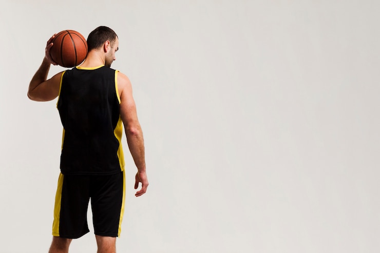 Free Photo back view of basketball player holding ball on shoulder with copy space