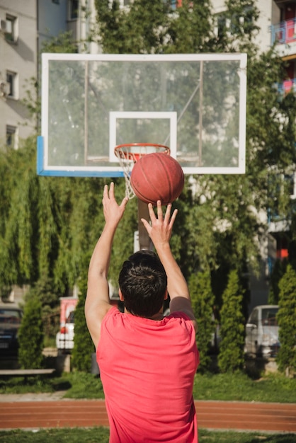 Free photo back view of basketball player throwing