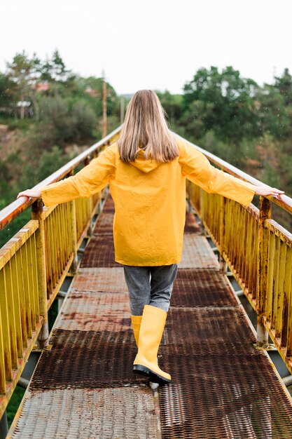 Free photo back view blonde woman wearing rain clothes