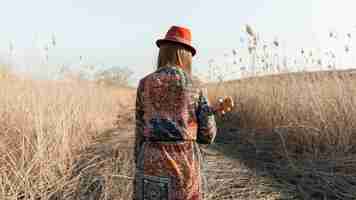 Free photo back view of bohemian woman with ukulele in nature