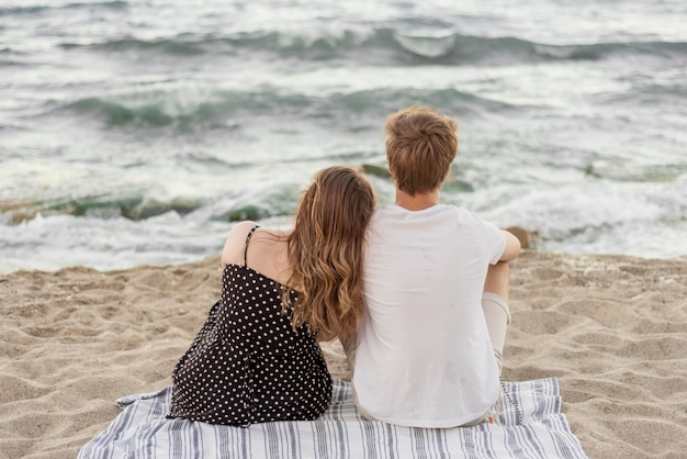 Foto gratuita vista posteriore ragazzo e ragazza che stanno insieme sulla spiaggia