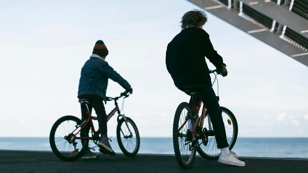 彼らの自転車で街の屋外の男の子の背面図