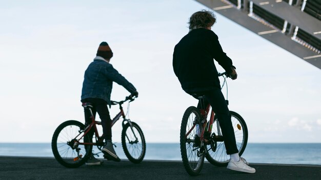 Back view of boys outdoors in the city with their bikes