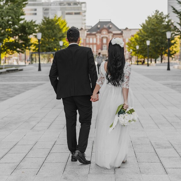 Back view of bride and groom walking down the street