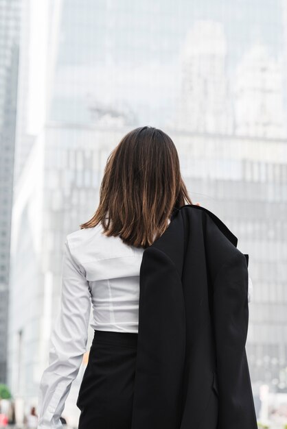 Вид сзади деловая женщина держит пиджак
