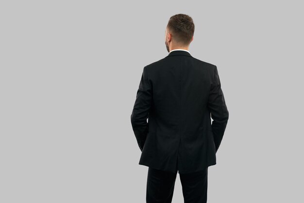 Back view of businessman with hands in pockets