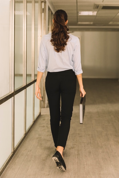 Free photo back view of businesswoman walking