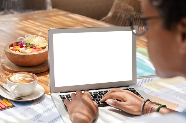 Back view of businesswoman works on netbook